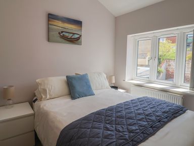A bedroom with a bed and nightstand at Beck House in Weymouth