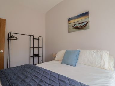 A bedroom with a bed and clothes rack at Beck House in Weymouth