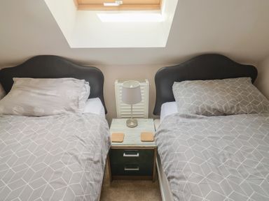 A bedroom with two beds and a nightstand at Beck House in Weymouth