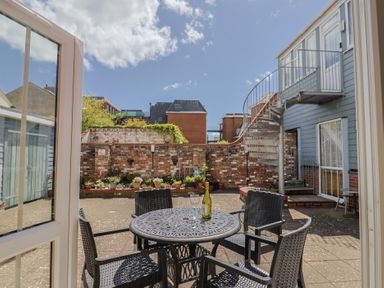 A courtyard with a table and chairs at Beck House in Weymouth