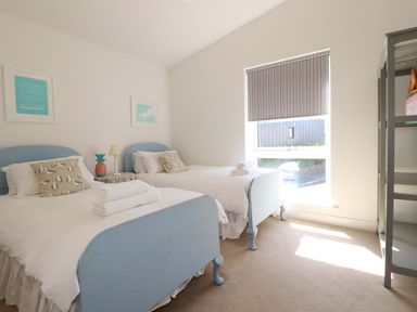 A bedroom with two beds and a window at Serfaus in Perranporth