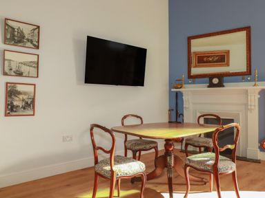 A dining room with a table and chairs at Farthings, The Old Chapel in St Austell