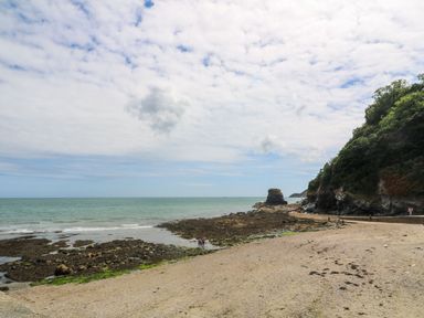 A beach with rocks and people at the shore near St Austell