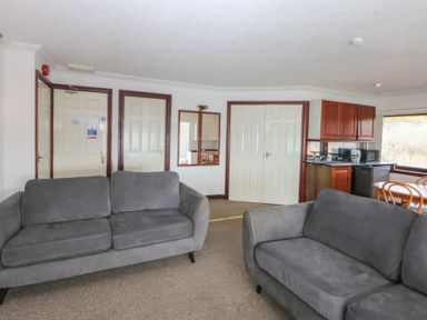 A living room with sofas and kitchen units at Seaview in Y Felinheli