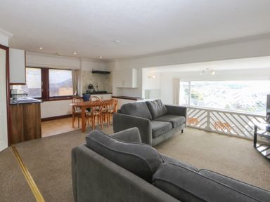 A living room with a sofa and dining area at Seaview in Y Felinheli