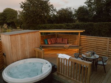An outdoor seating area with a hot tub at Exclusive Tempest Spa in Grimsby