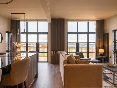 A living room with a sofa and dining area at Exclusive Tempest Spa in Grimsby