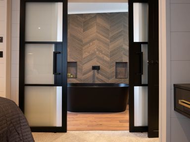 A bathroom with a bathtub and wooden wall features at Exclusive Tempest Spa in Grimsby