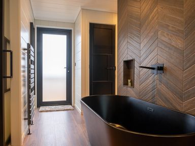 A bathroom featuring a bathtub and towel rack at Exclusive Tempest Spa in Grimsby