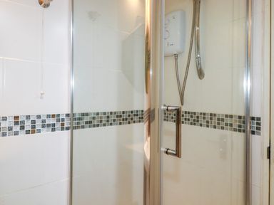 A shower with controls and tiles at 18 Tregea Terrace in Portreath