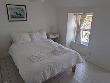 A bedroom with a bed and nightstand at Fairsands in Portreath