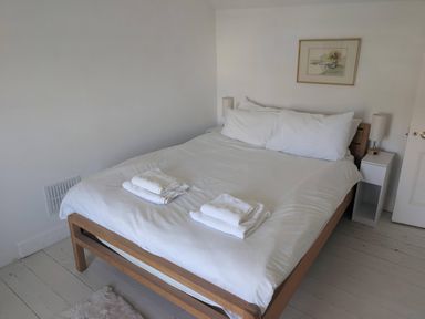 A bedroom with a bed and bedside tables at Fairsands in Portreath