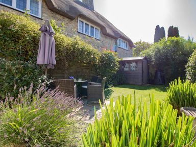 A garden with seating area and shed at Honeypot Cottage in Weymouth