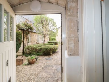 A view from the entrance showing a pathway and greenery at Longfords Mill near Nailsworth