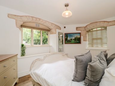 A bedroom with a bed and dresser at Longfords Mill, Minchinhampton