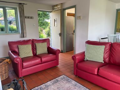 A living room with sofas and a door leading to the kitchen at Wren Cottage in Cowbridge