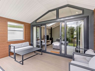 A conservatory with a sofa and coffee table at Prion 1.0 Pet in Llandyrnog