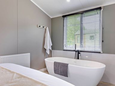 A bathroom with a bathtub and towel at Prion 1.0 Pet in Llandyrnog