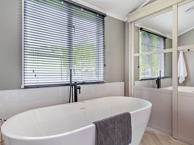 A bathroom with a bathtub and a window at Prion 1.0 Pet in Llandyrnog