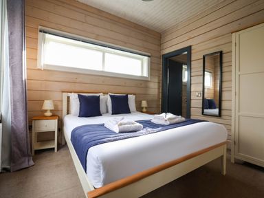 A bedroom with a bed and bedside table at Pine Lodge Spa Carlton Miniott near Thirsk