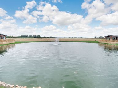 An outdoor area with a pond and fountain at Pine Lodge Spa Carlton Miniott near Thirsk
