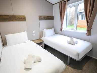 A bedroom with single and twin beds at Laurel Waterside Spa Carlton Miniott near Thirsk