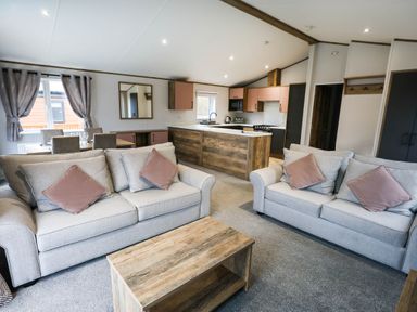 A living room with a sofa and dining area at Laurel Waterside Spa Carlton Miniott near Thirsk