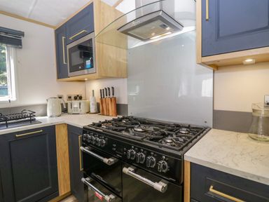 A kitchen with an oven and microwave at 51 Calgarth Park in Troutbeck