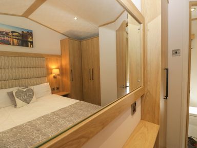 A bedroom with a bed and wardrobe at 51 Calgarth Park in Troutbeck