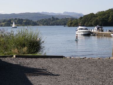 A lake with boats and a person on a paddleboard at 51 Calgarth Park in Troutbeck