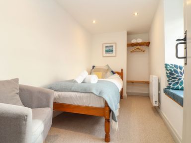 A bedroom with a single bed and chair at Ty Bryn in Marazion