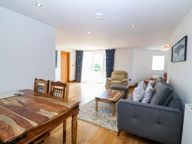 A living room with a dining table and sofa at Apartment 1, Bryn Mel Manor in Menai Bridge
