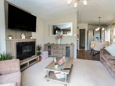 A living room with a television and coffee table at The Norfolk Nook 18 Castle Walk Burgh Castle