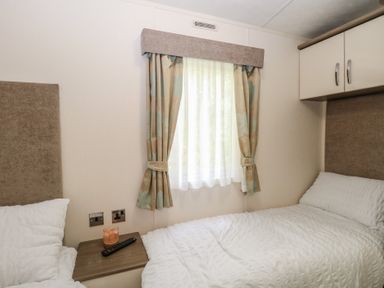A bedroom with two beds and a window at The Norfolk Nook 18 Castle Walk Burgh Castle
