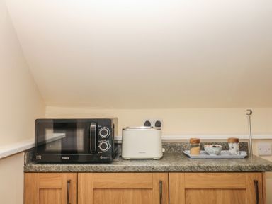 A kitchen with a microwave and toaster at The Mill Barn in Lustleigh