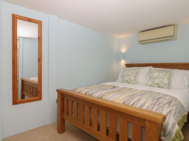 A bedroom with a bed and a mirror at The Mill Barn in Lustleigh