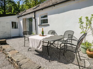 An outdoor dining area with a table and chairs at Daffodil Cottage in Blaencwm near Treorchy