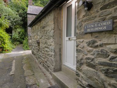 A building entrance with a stone wall and pathway at Llety Cllyd Barmouth
