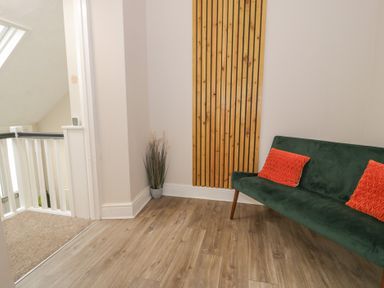 A hallway with a sofa and potted plant at Llety Cllyd in Barmouth