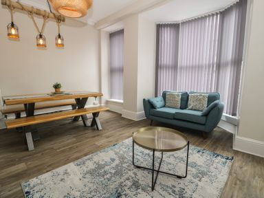 A dining area with a table and benches at Llety Cllyd in Barmouth