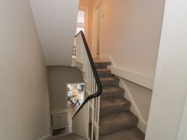 A staircase with a handrail and doorway at Llety Cllyd in Barmouth