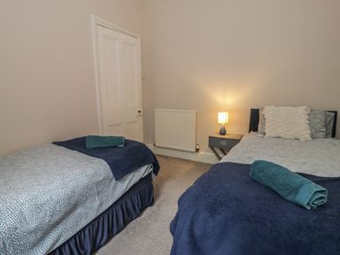 A bedroom with two beds and a bedside table at Llety Cllyd in Barmouth