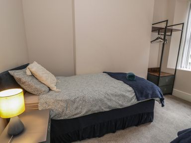 A bedroom with a bed and wardrobe at Llety Cllyd in Barmouth