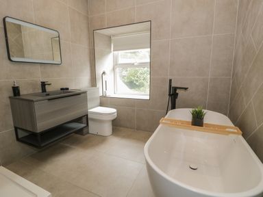 A bathroom with a bathtub, toilet, and vanity at Llety Cllyd in Barmouth