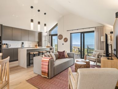 A living room with a kitchen and seating area at Clifftop House Hot Tub in St Ives
