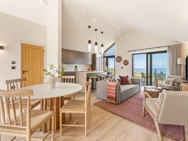 A living room with a round table and chairs at Clifftop House Hot Tub St Ives