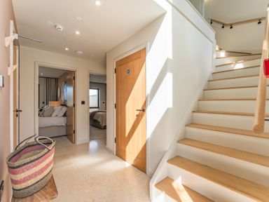 A hallway with a staircase and doors at Clifftop House Hot Tub in St Ives