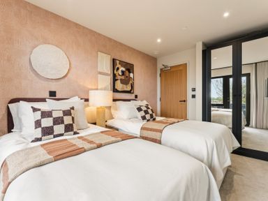 A bedroom with two beds and artwork on the wall at Clifftop House Hot Tub, St Ives