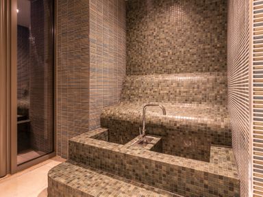 A steam room with mosaic tiles and a water faucet at Hidden 1- Clifftop House Hot Tub in St Ives