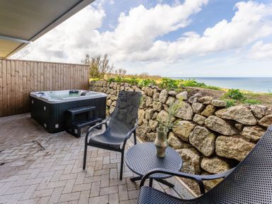 An outdoor area with a hot tub and seating at tbc St. Ives